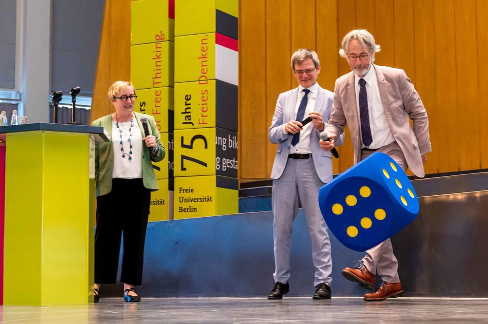Angeleitet von Verena Blechinger-Talcott (li.) konnten die Vizepräsidenten der Technische Universität Berlin, Stephan Völker (Mitte), und der Humboldt-Universität, Christoph Schneider (re.), beim Würfel-Quiz mehr über das Geburtstagskind erfahren.