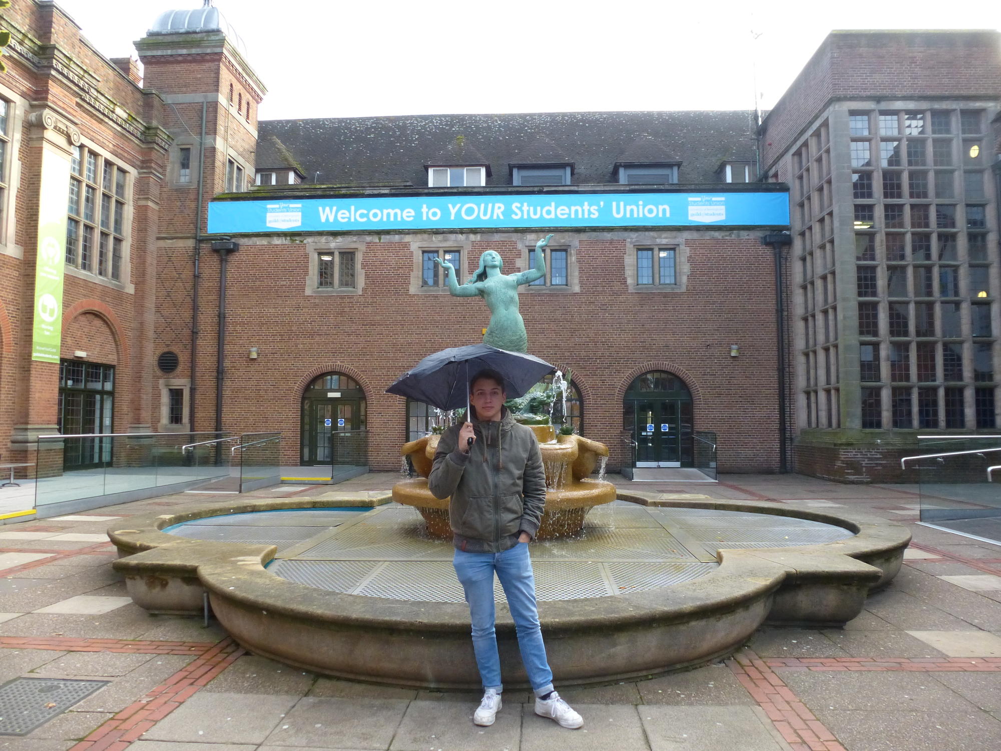 Ben Heiden with the requisite umbrella in front of the Guild of Students, where the weekly student union party is held.