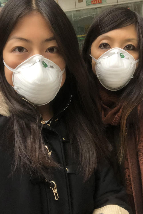 Masks on at all times: Vivi Feng (left) and her sister in Shanghai. Vivi Feng is now back in Germany.