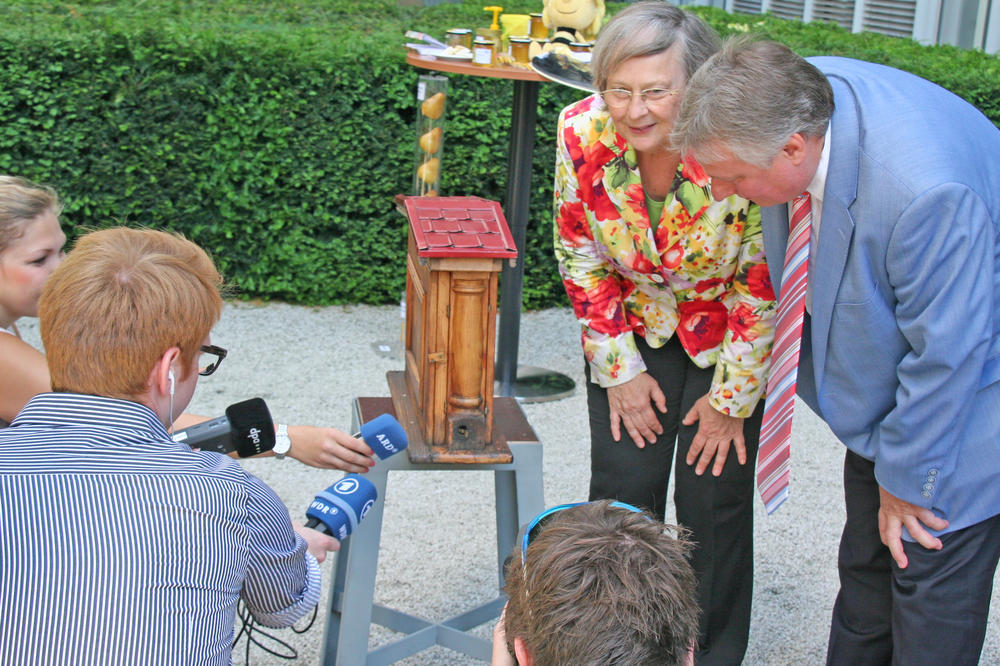 Summt da was? Bärbel Höhn inspiziert gemeinsam mit Journalisten den Bienenkasten.