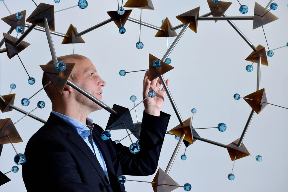 Chemie-Nobelpreisträger Benjamin List betrachtet ein Molekül Modell.