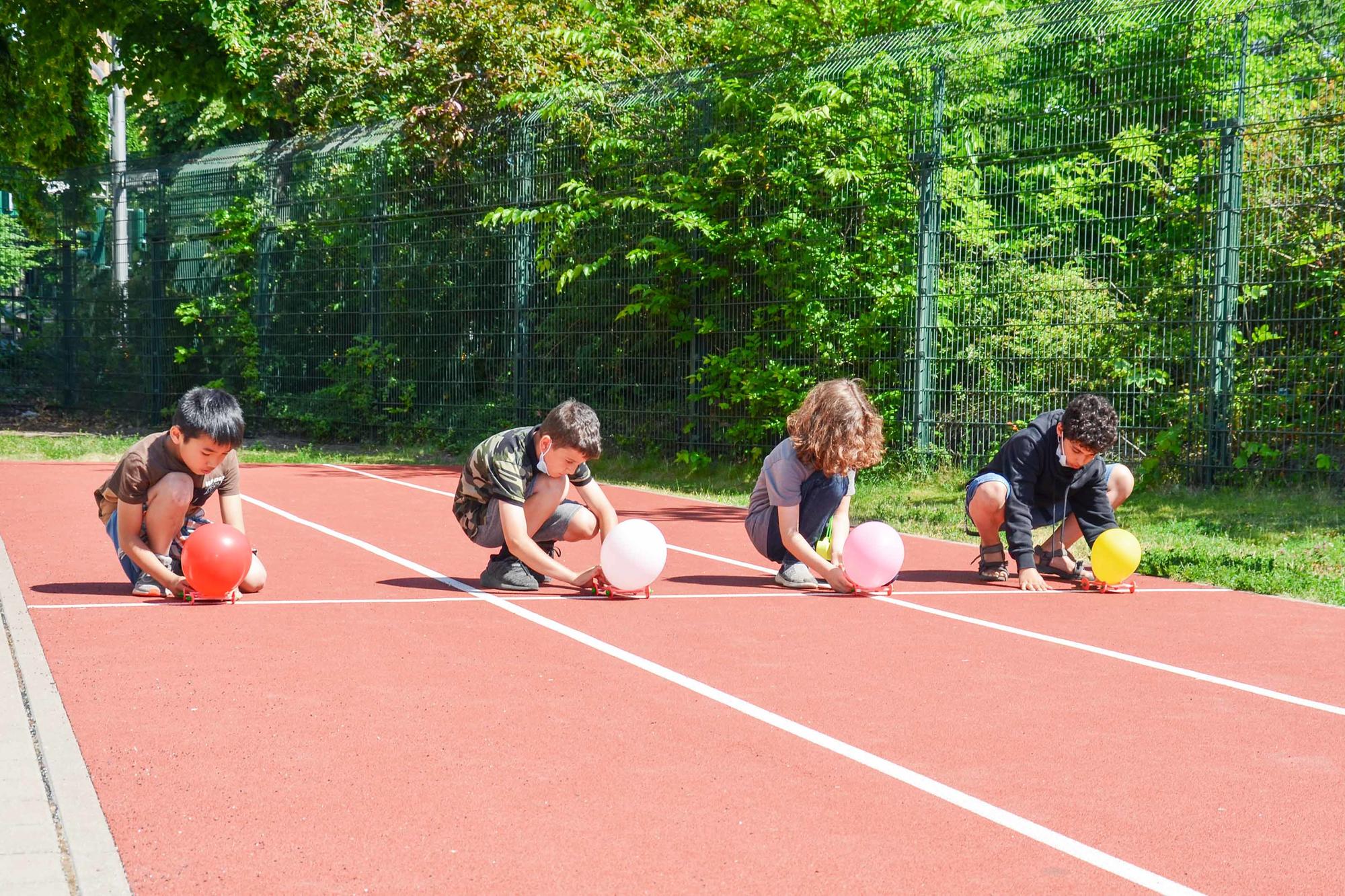 Am Start mit von Ballons angetriebenen Fahrzeugen. Eine Abschlussveranstaltung fand an der Charlotte-Salomon-Grundschule in Berlin-Kreuzberg statt.