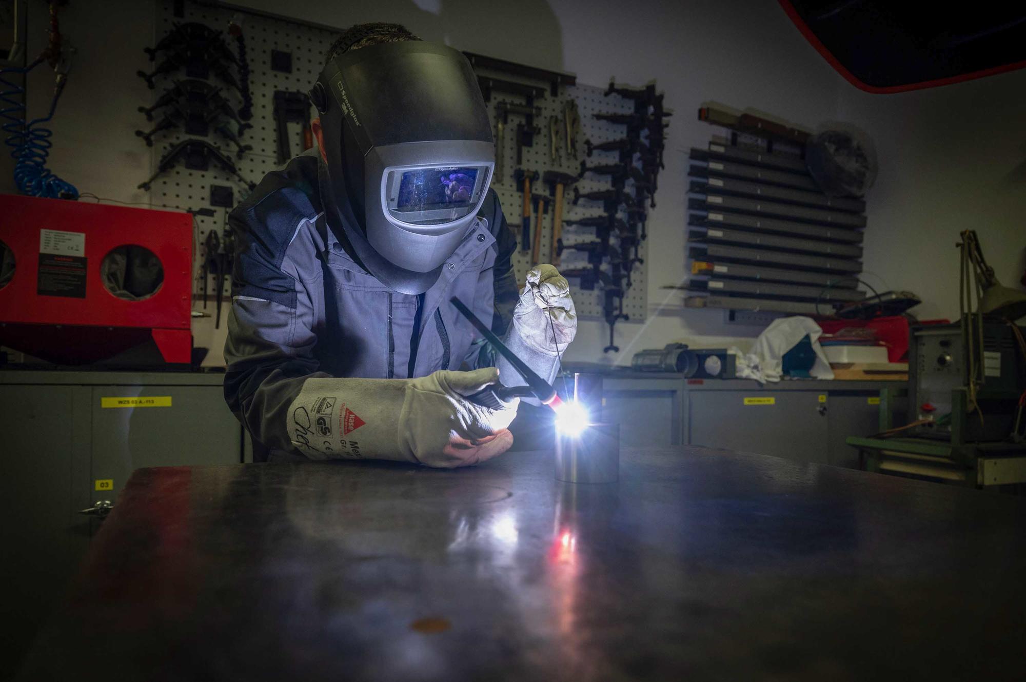 Werkstattleiter Frank Totzauer in Schutzkleidung beim Schweißen in der Werkstatt