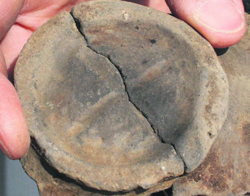 Die eisenzeitliche Tonscherbe zeigt einWagenrad. Es symbolisiert den Glauben der Siedler an den Sonnengott, der von Osten nach Westen über den Himmel fährt.