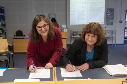 Unterzeichnung der Schenkung durch Matthia Rischke von der Schule für Logopädie am Berliner Bildungscampus für Gesundheitsberufe und Birgit Rehse vom Universiätsarchiv der FU Berlin (v. r. n. l.)